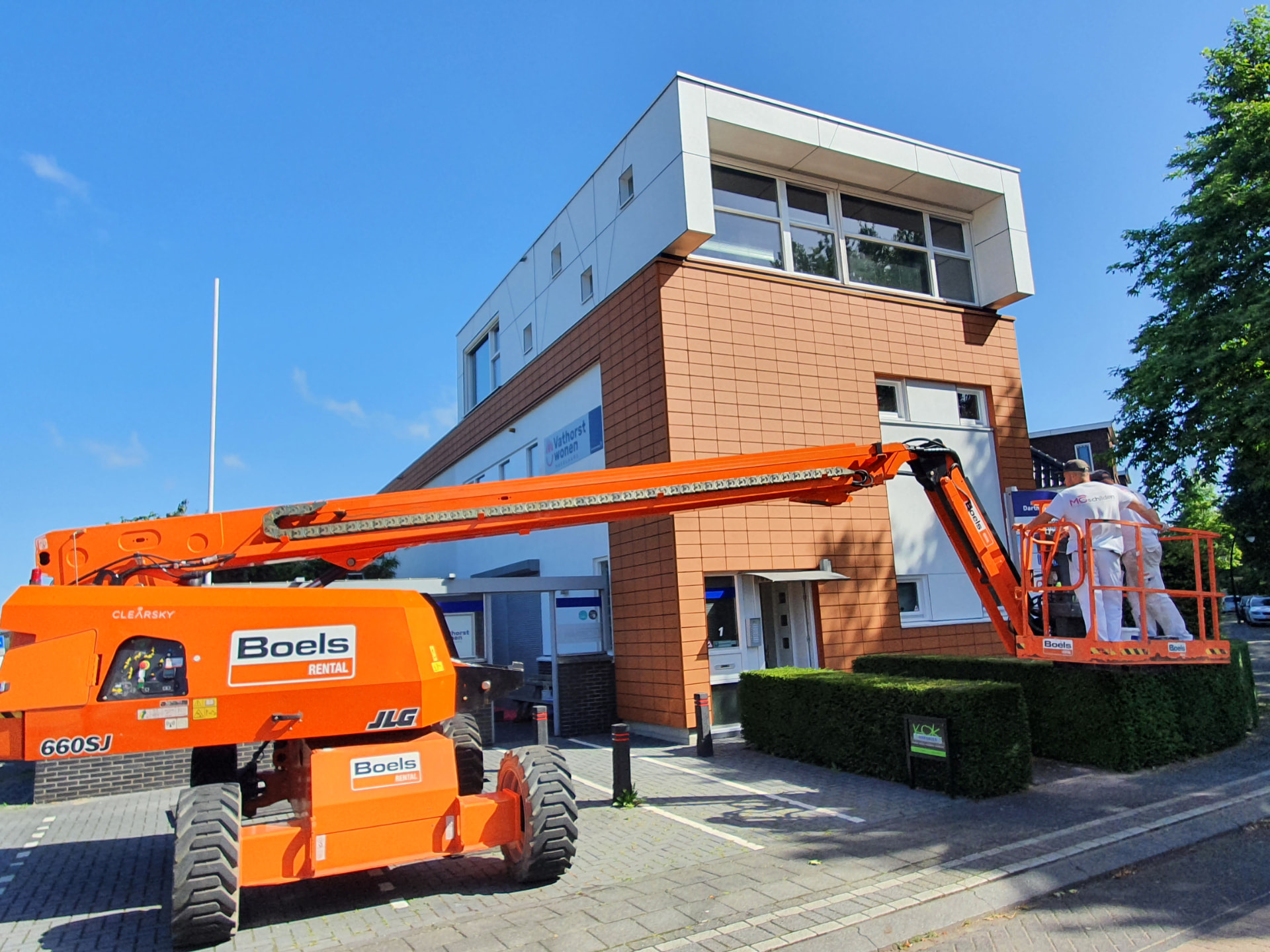Hoogwerker langs de gevel van een kantoorpand